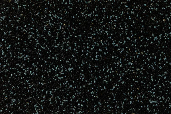 Декоративная мозаичная штукатурка с цветным наполнителем Baumit MosaikTop M332 25 кг 1 Крупный план черной плитки с синими крапинками, покрытой Декоративной мозаичной штукатуркой с цветным наполнителем Baumit MosaikTop M332 25 кг, декоративной мозаичной штукатуркой с цветным наполнителем. в Москве